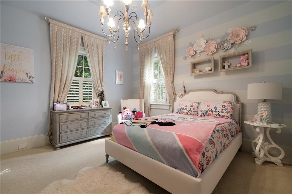 4136 North Stratford Road Northeast Atlanta, GA 30342 - Photo 46 of 78 a bedroom with a bed and a chandelier