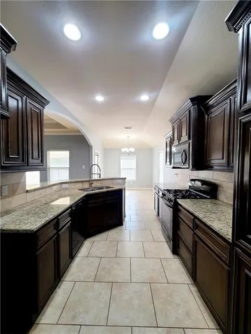 a large kitchen with granite countertop stainless steel appliances and a sink