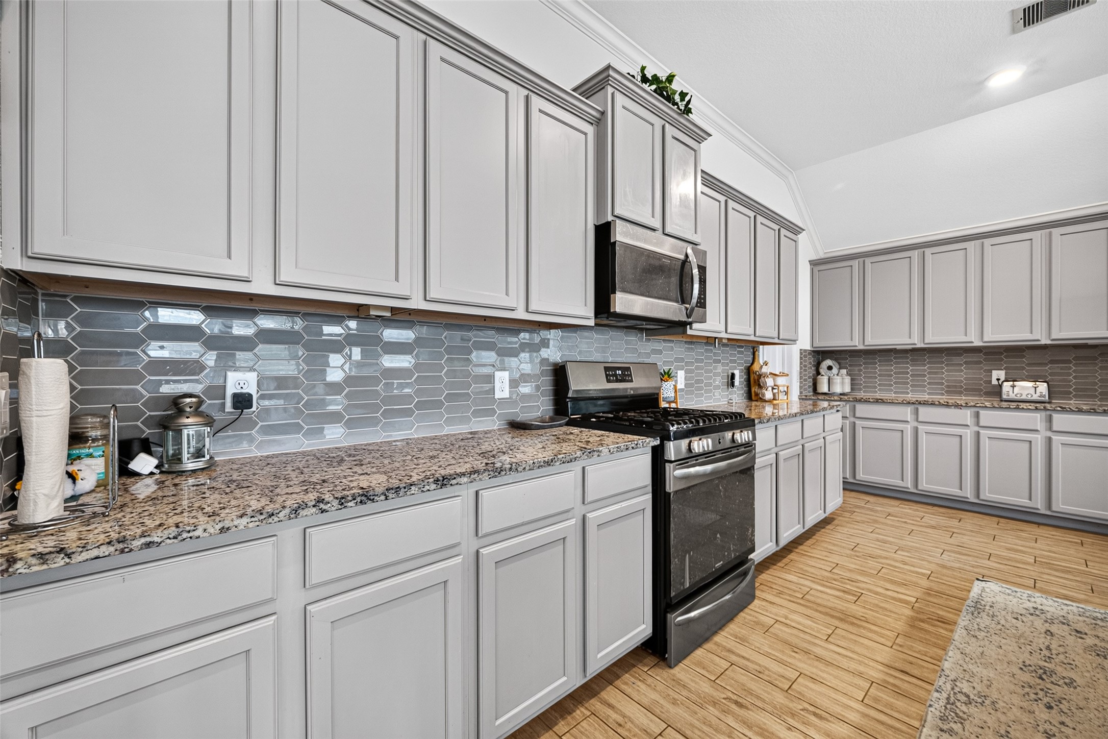 4441 Jessamine Creek Trail Rosharon, TX 77583 - Photo 11 of 42 The kitchen makes a statement with soft gray cabinetry, granite countertops, and a striking geometric tile backsplash. Stainless-steel appliances complement the finishes, while extensive counter space provides plenty of room for meal preparation.