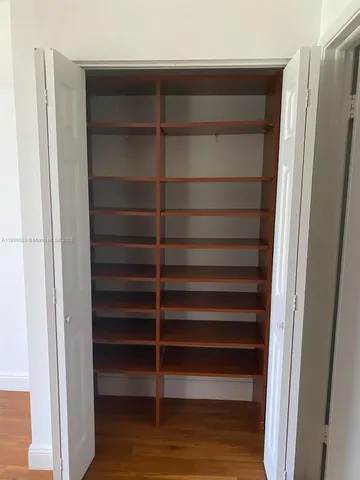 an empty room with wooden floor and closet