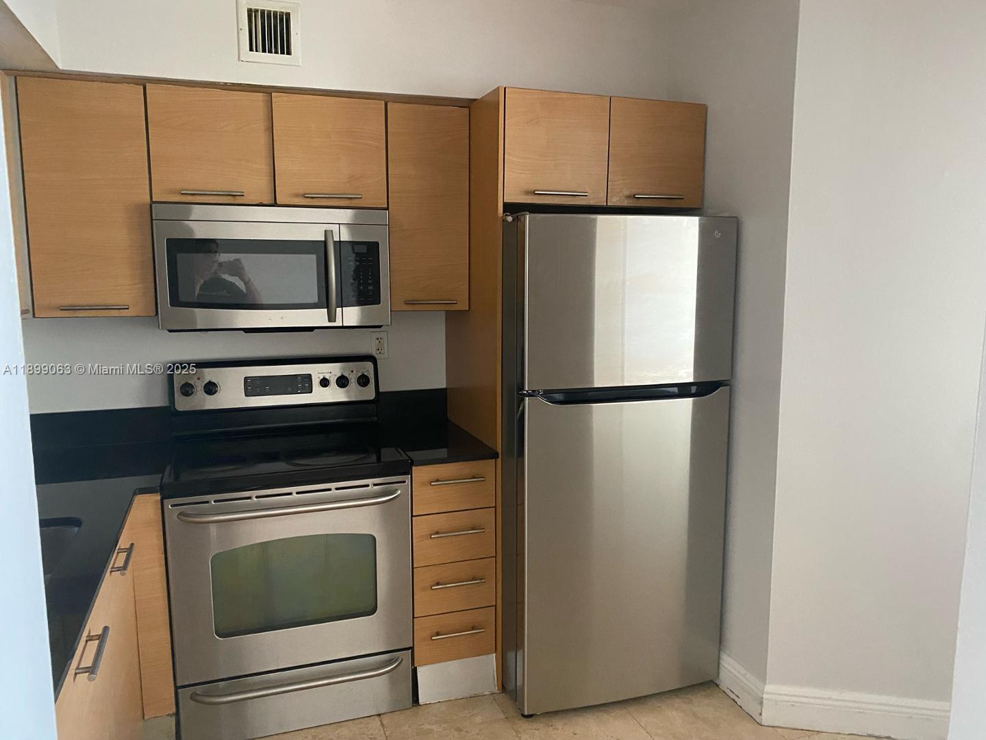 3300 Northeast 191st Street, Unit 416 Aventura, FL 33180 - Photo 5 of 26 a kitchen with a refrigerator stove and microwave