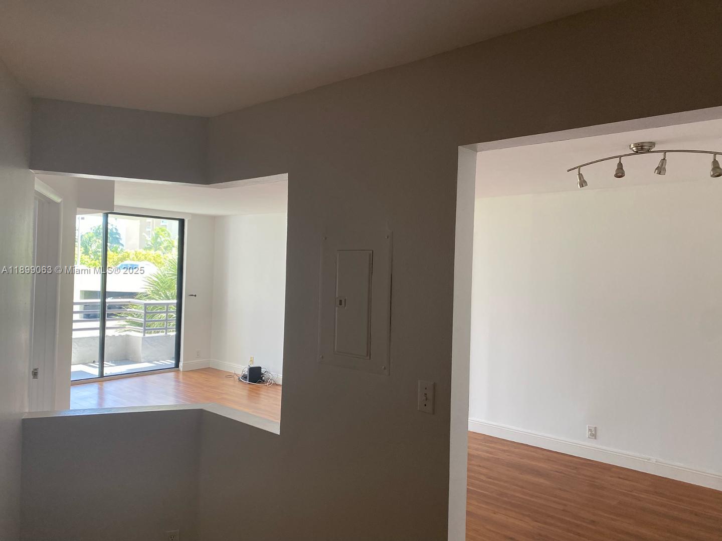 3300 Northeast 191st Street, Unit 416 Aventura, FL 33180 - Photo 6 of 26 a view of an empty room with wooden floor and a window