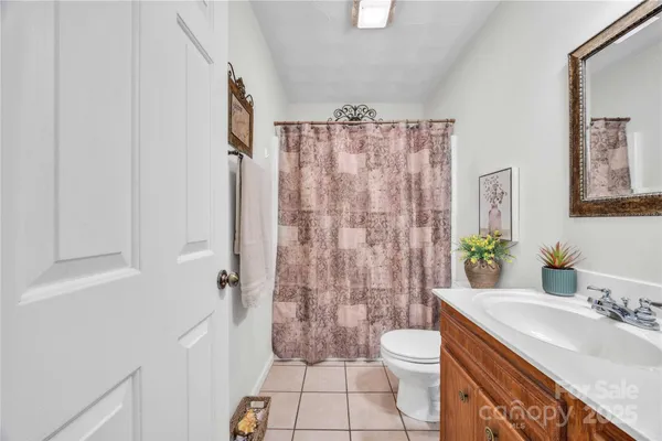 a bathroom with a granite countertop sink toilet a mirror a vanity and shower
