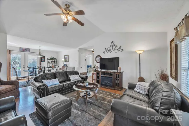 a living room with furniture a flat screen tv and kitchen view