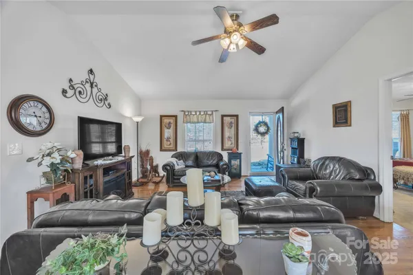 a living room with furniture a flat screen tv and a fireplace