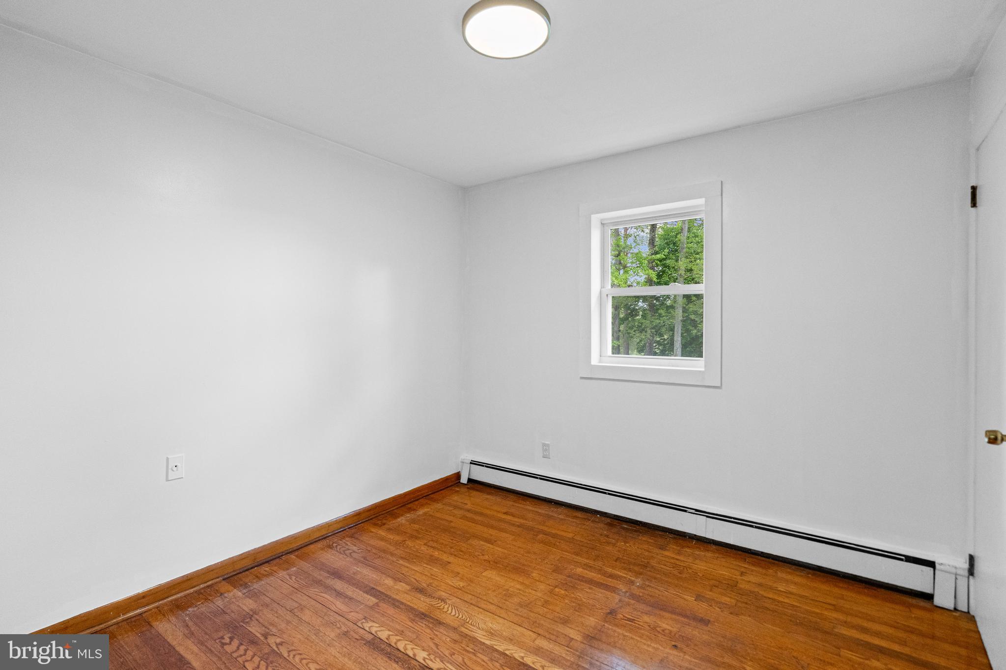 16811 Ridge Road Upperco, MD 21155 - Photo 13 of 22 a view of an empty room with wooden floor and a window