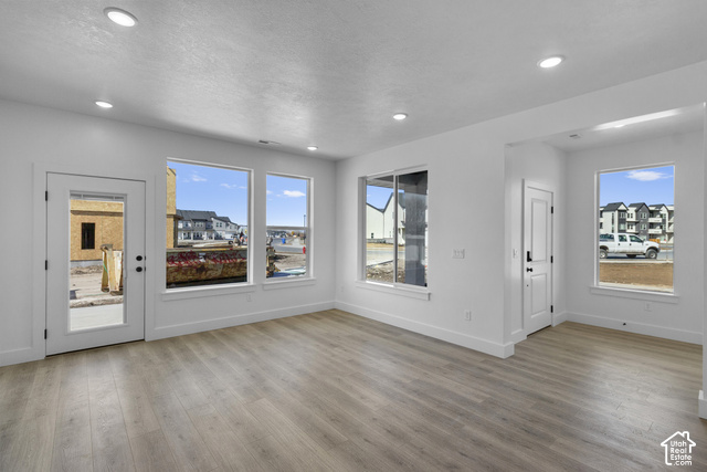 249 West 2920th Street South Logan, UT 84321 - Photo 4 of 23 Recessed ceiling lighting, wood-finish flooring, white walls, multiple windows, and a glass-paneled door