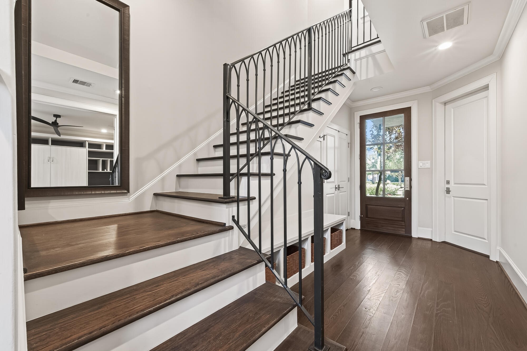 122 Gateway Park Place Spring, TX 77380 - Photo 12 of 44 A striking staircase with iron railings, upgraded wood floors, and bright entryway with glass-front door.