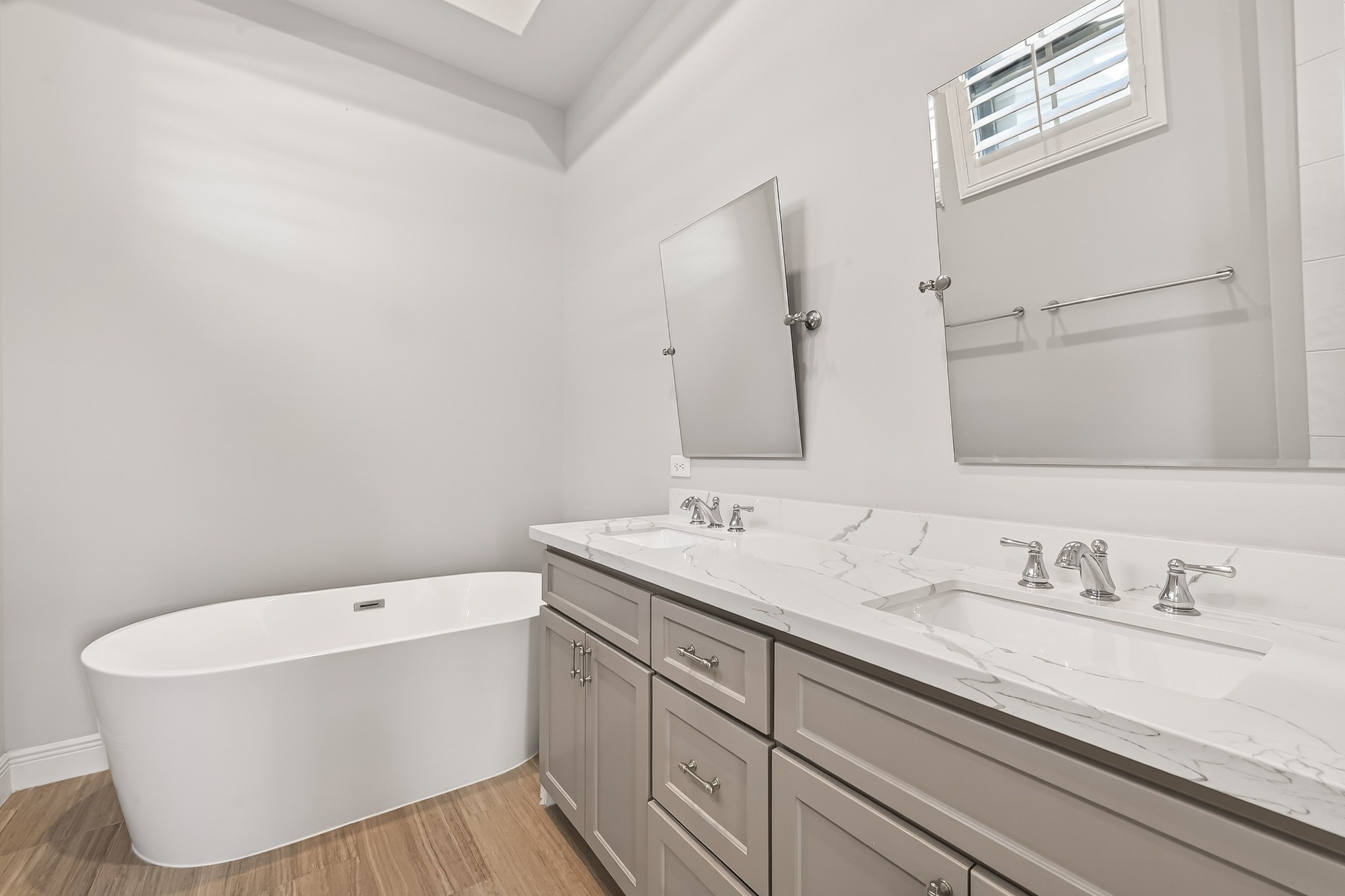122 Gateway Park Place Spring, TX 77380 - Photo 31 of 44 Spa-inspired bath with freestanding tub, double vanity, and elegant quartz countertops under vaulted ceilings.