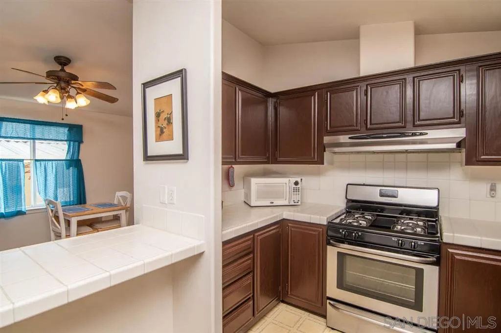 1810 Hillsdale Road, Unit 85 El Cajon, CA 92019 - Photo 17 of 23 a kitchen with granite countertop a stove cabinets and microwave