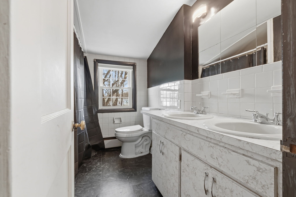287 Main Street Saugus, MA 01906 - Photo 21 of 24 a bathroom with a toilet sink and mirror