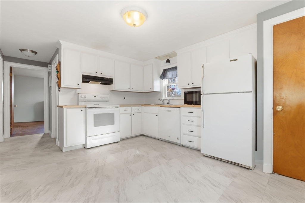 287 Main Street Saugus, MA 01906 - Photo 3 of 24 a kitchen with white cabinets and white appliances