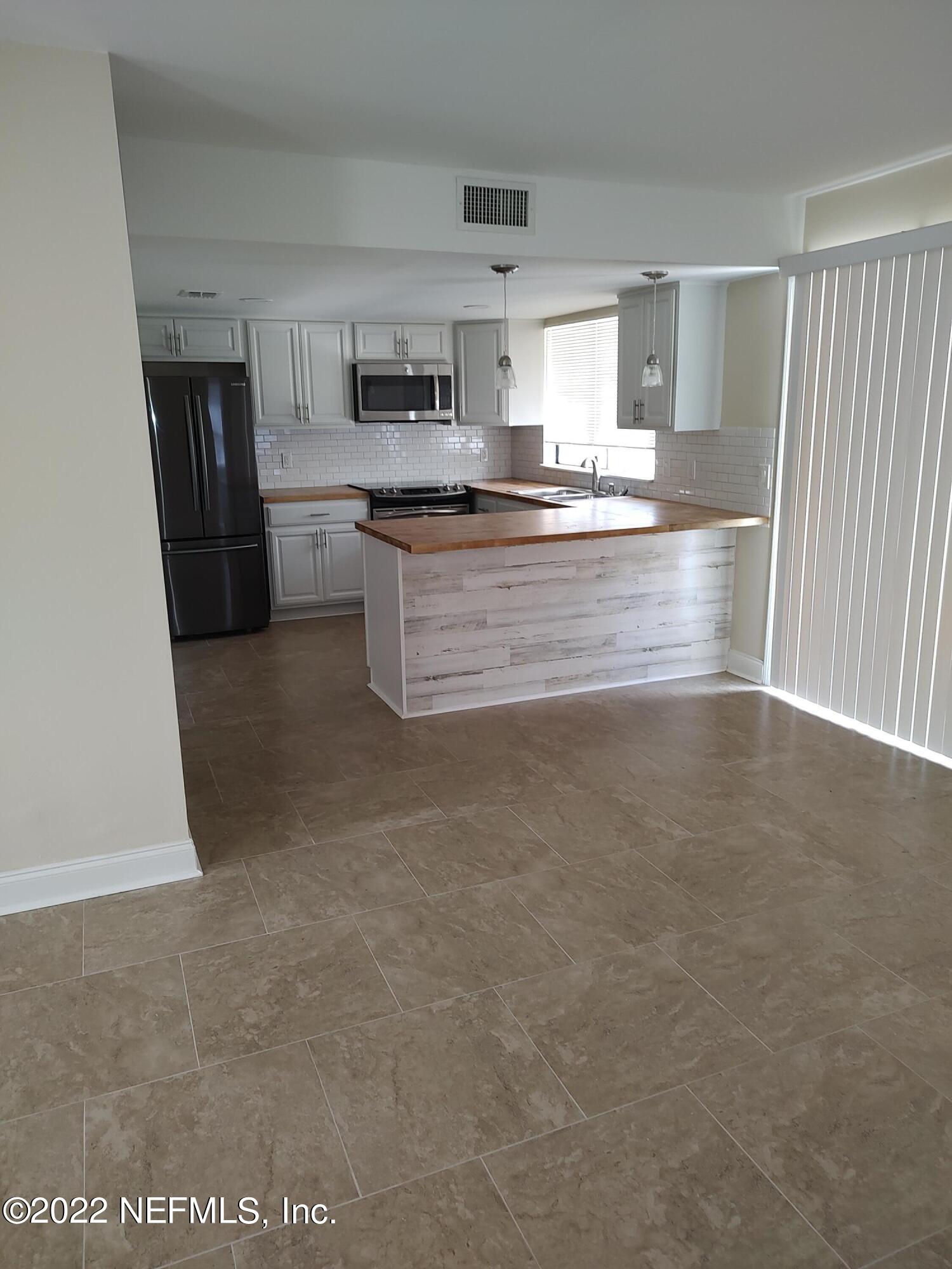 3517 Peeler Road, Unit 13 Jacksonville, FL 32277 - Photo 11 of 31 a kitchen with stainless steel appliances granite countertop a stove a sink and a refrigerator