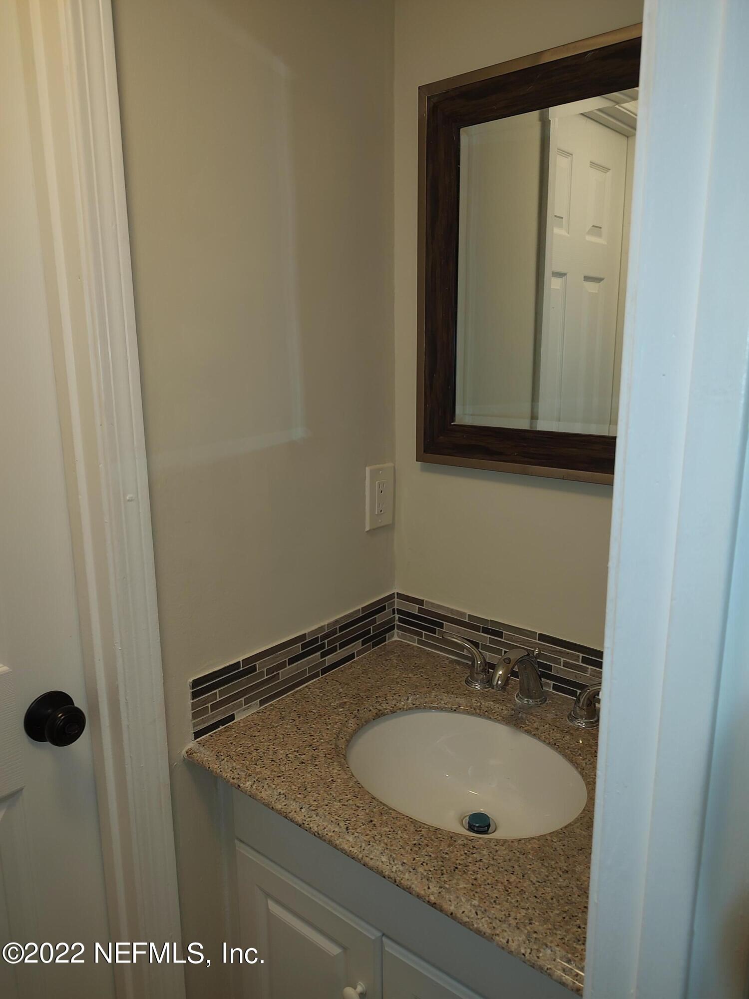 3517 Peeler Road, Unit 13 Jacksonville, FL 32277 - Photo 14 of 31 a bathroom with a granite countertop sink and a mirror