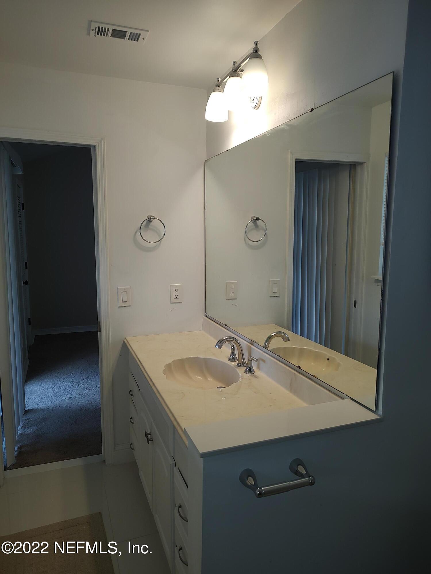 3517 Peeler Road, Unit 13 Jacksonville, FL 32277 - Photo 21 of 31 a bathroom with a sink and a mirror