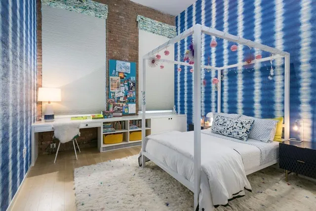 a bedroom with a bed and large windows