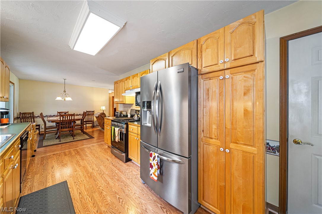 431 Ansel Road Geneva, OH 44041 - Photo 21 of 35 Kitchen with brown cabinets, stainless steel appliances, and light hardwood flooring