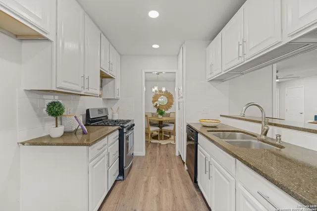 a kitchen with kitchen island granite countertop a sink stove refrigerator and cabinets