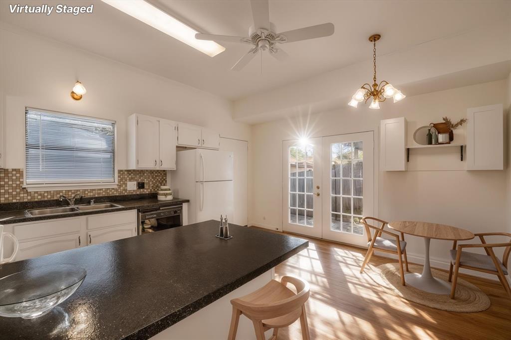 1300 Chapel Downs Waco, TX 76712 - Photo 7 of 38 a kitchen with stainless steel appliances granite countertop a stove top oven a sink a dining table and chairs with wooden floor