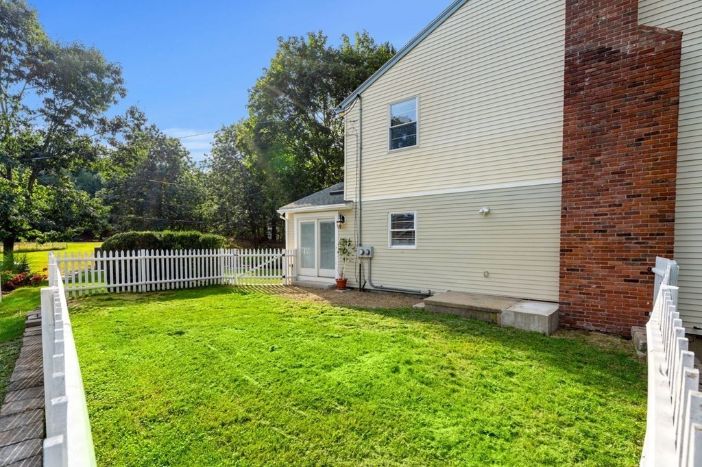 22 Fosters Pond Road Andover, MA 01810 - Photo 33 of 42 a view of a white house with a small yard and a large tree