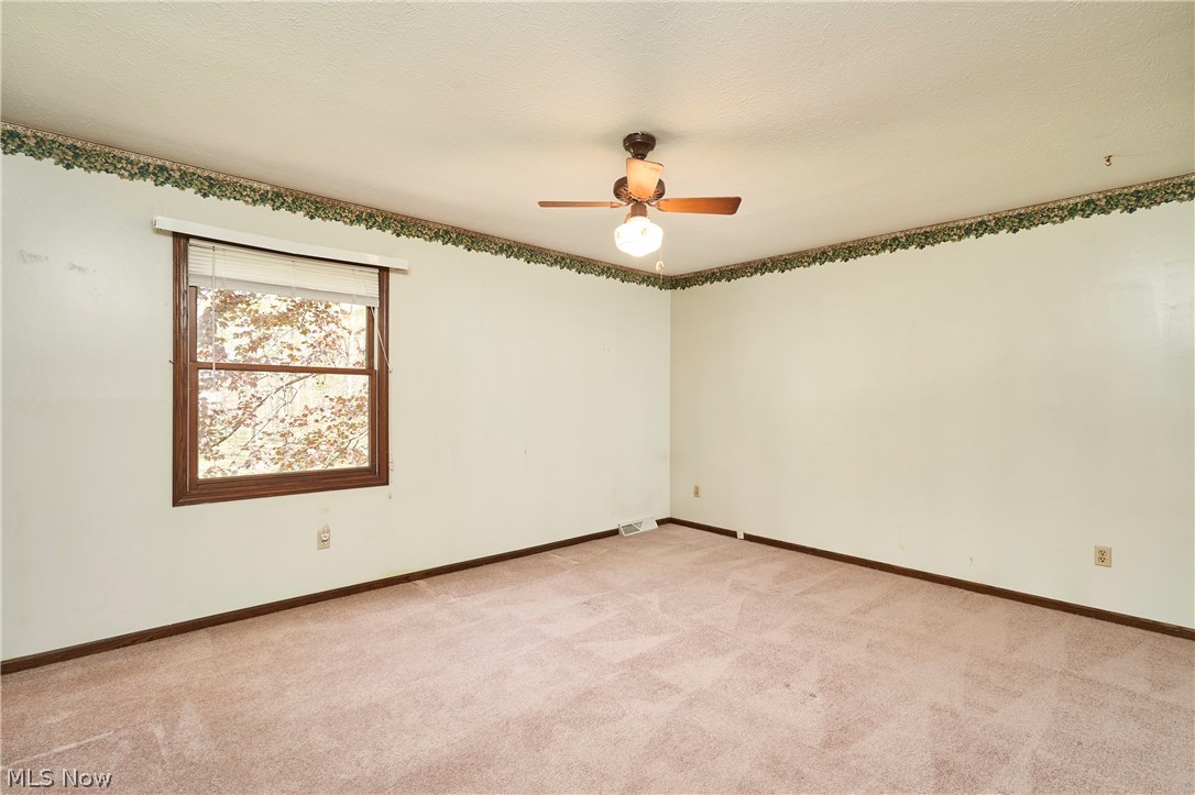 3097 Baughman Road Clinton, OH 44216 - Photo 13 of 27 Spacious second master bedroom featuring neutral carpeting, light-colored walls, and a ceiling fan with integrated lighting
