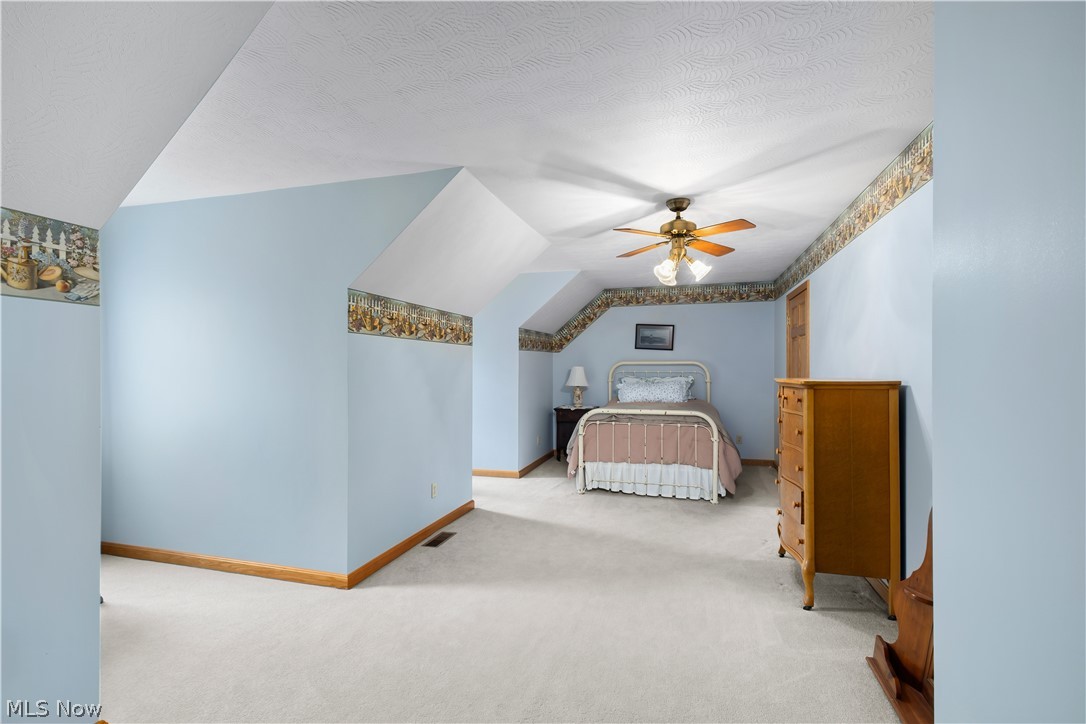 10909 Ruby Road Cambridge, OH 43725 - Photo 28 of 34 Carpeted bedroom featuring vaulted ceiling, ceiling fan, and a textured ceiling