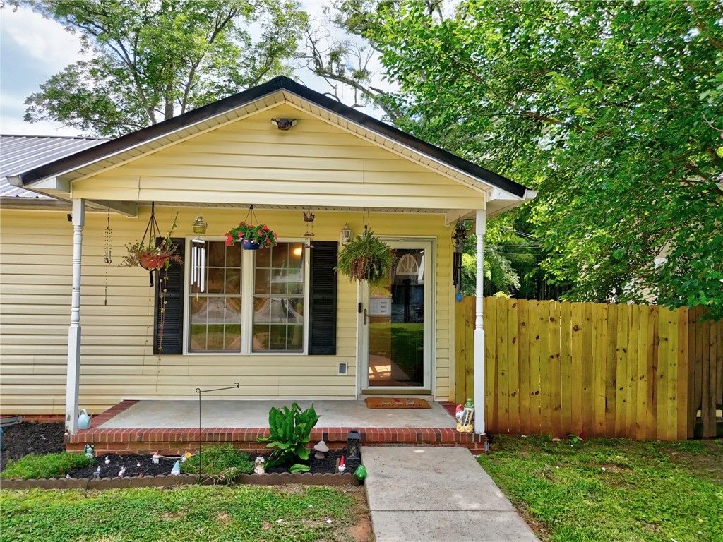 1020 Elizabeth Street Anderson, SC 29624 - Photo 2 of 22 A welcoming yellow-sided dwelling with a classic porch and a new privacy fence.
