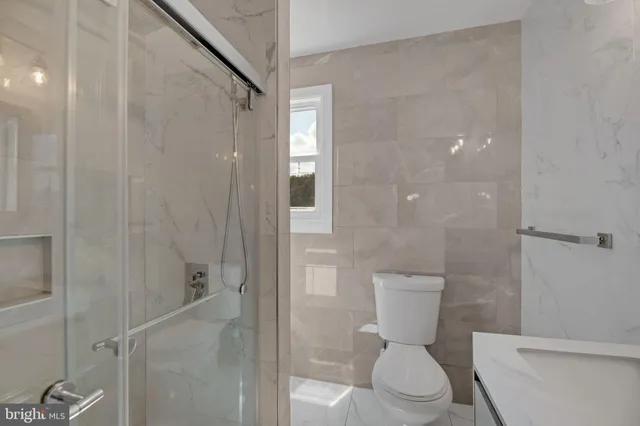 a white toilet sitting next to a bathroom sink