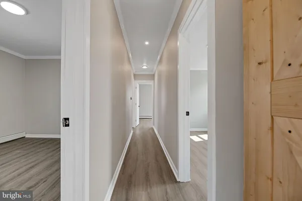a view of a hallway with wooden floor