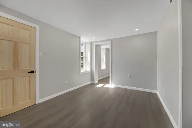 a view of an empty room with wooden floor
