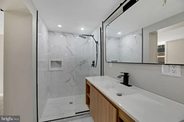a bathroom with a shower sink and mirror