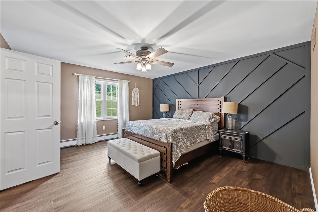9868 Stagecoach Road Kempton, PA 19529 - Photo 9 of 17 An inviting bedroom features rich hardwood flooring and a uniquely textured accent wall.
