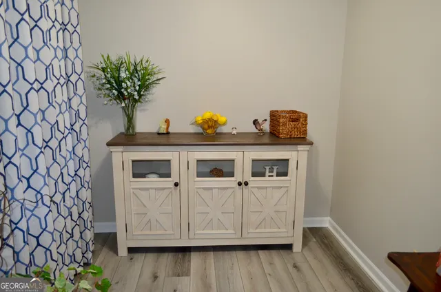 a kitchen with white cabinets and wooden floor