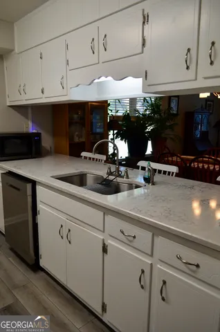 a kitchen with white cabinets and white appliances