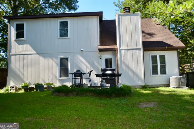 a view of a house with a yard and tree