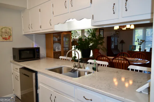 a kitchen with stainless steel appliances a sink a stove and cabinets
