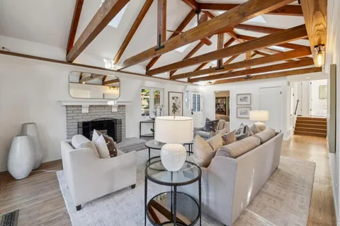 a dining room with furniture a chandelier and wooden floor