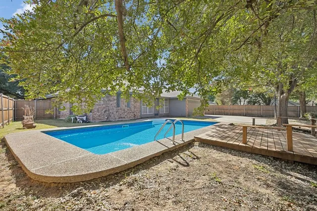 a view of a backyard with swimming pool