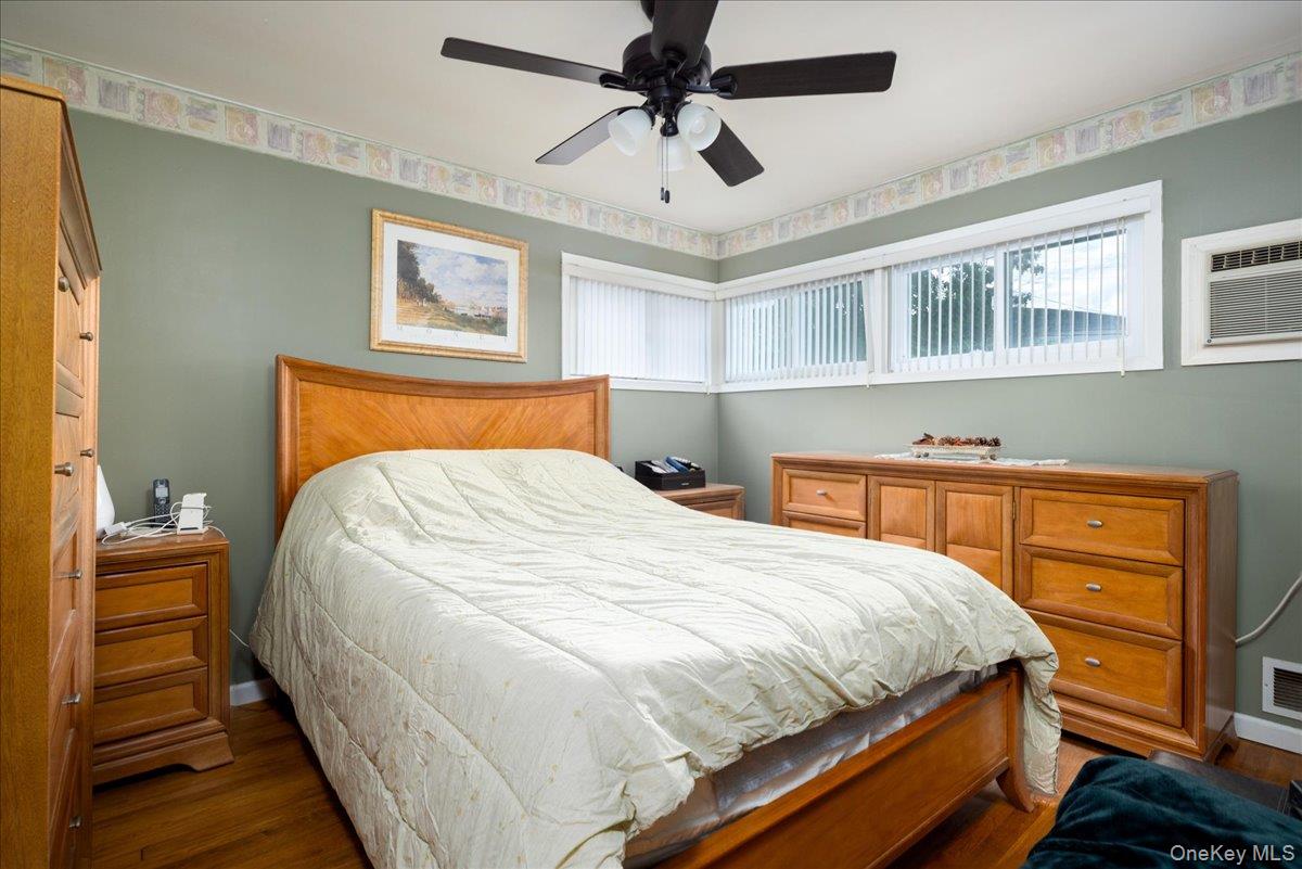 11 Adelphi Road Hicksville, NY 11801 - Photo 12 of 26 a bedroom with a bed and a chandelier