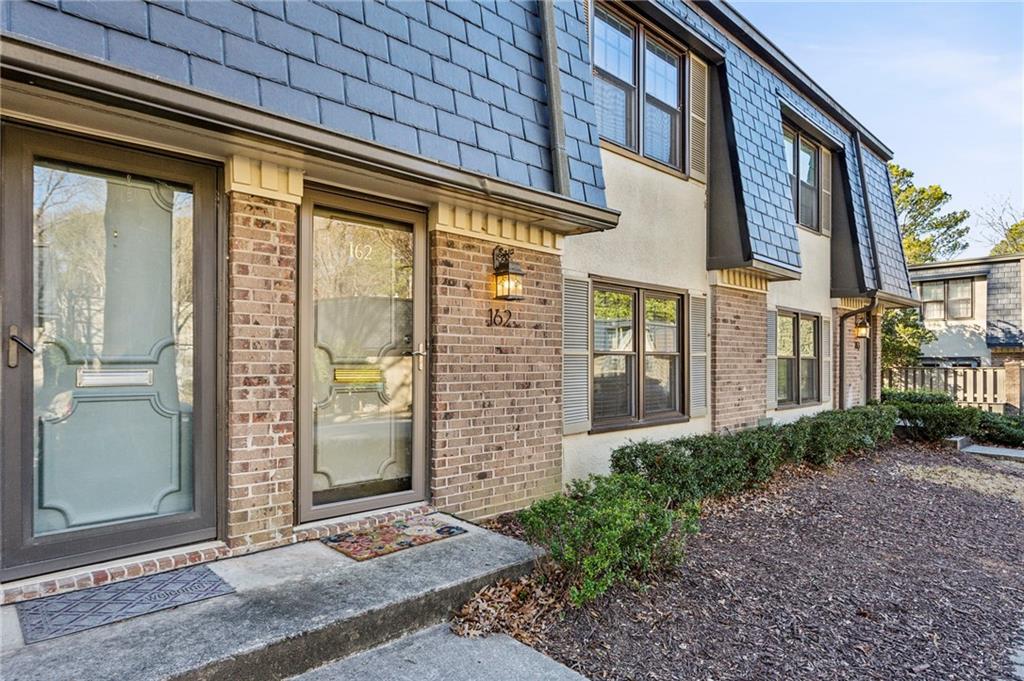162 Lablanc Way Northwest Atlanta, GA 30327 - Photo 2 of 22 a view of a brick house with a large windows