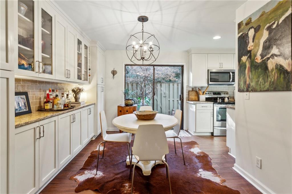 162 Lablanc Way Northwest Atlanta, GA 30327 - Photo 7 of 22 a dining room with wooden floor a chandelier a wooden table and chairs