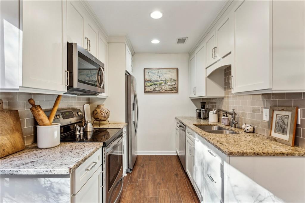 162 Lablanc Way Northwest Atlanta, GA 30327 - Photo 10 of 22 a kitchen with granite countertop a sink and a stove top oven