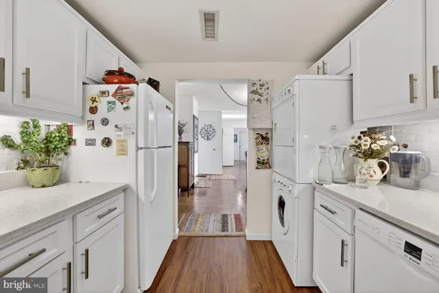a kitchen with granite countertop white cabinets and white appliances
