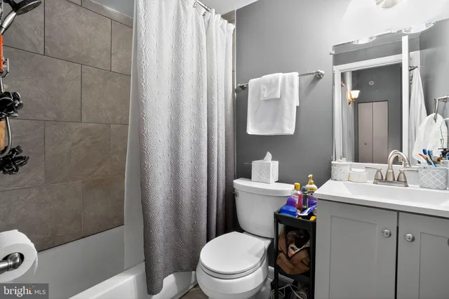 a bathroom with a sink a toilet a mirror and shower