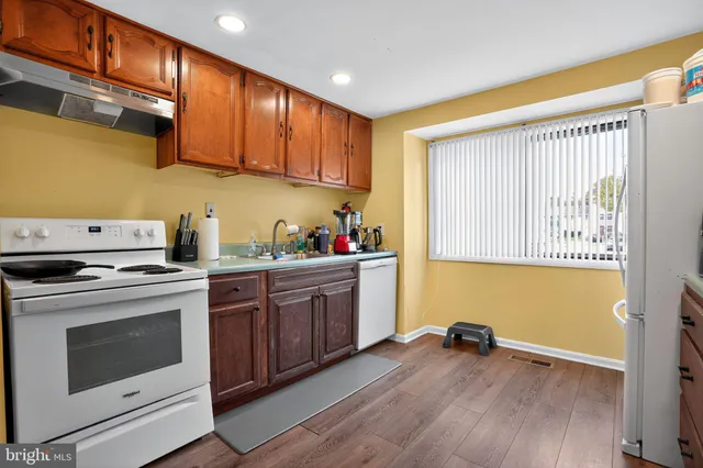 a kitchen with granite countertop wooden cabinets and white appliances