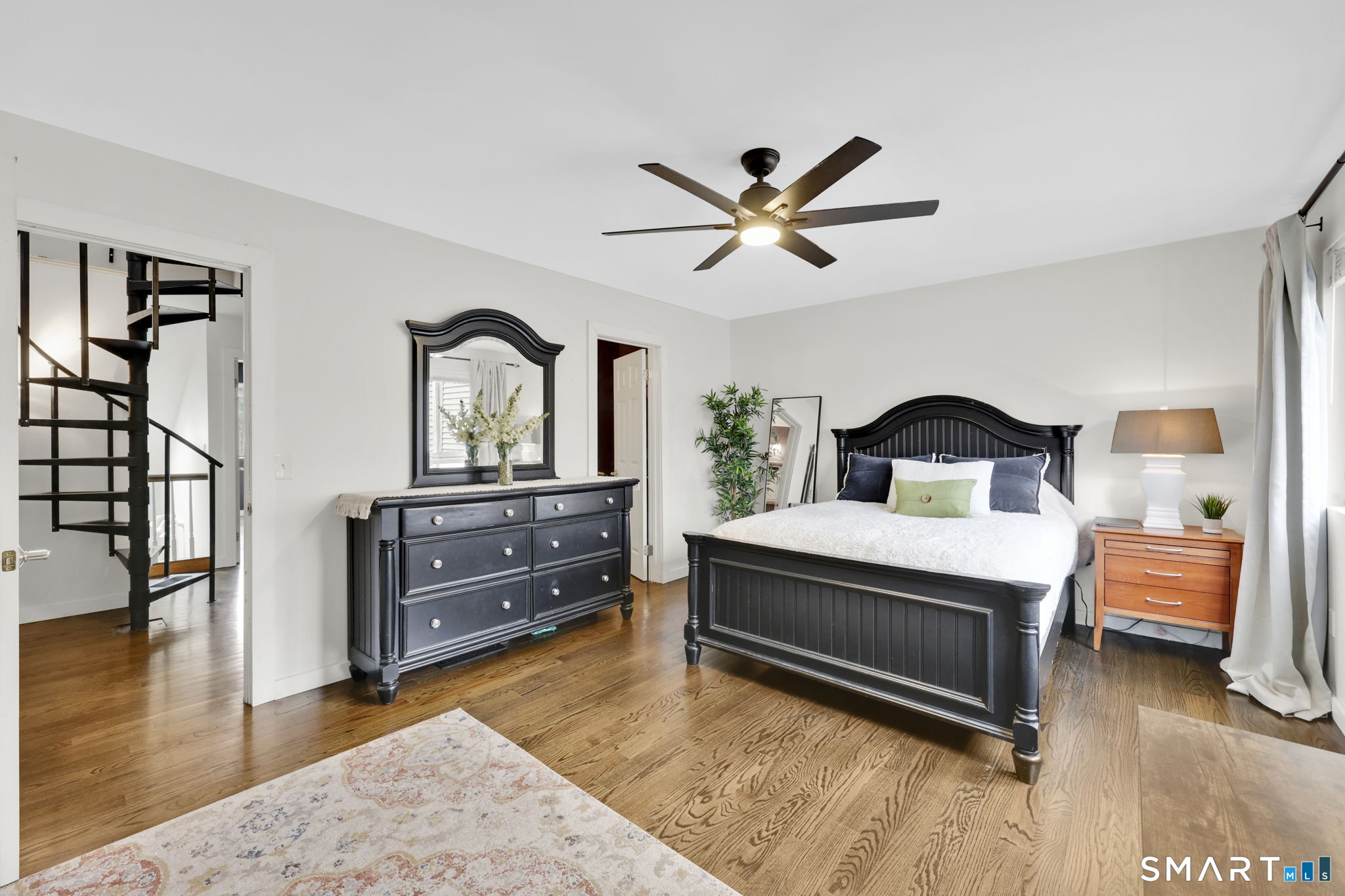 8 Whirling Dun, Unit 8 Canton, CT 06019 - Photo 11 of 28 a bedroom with a bed and a dresser with wooden floor