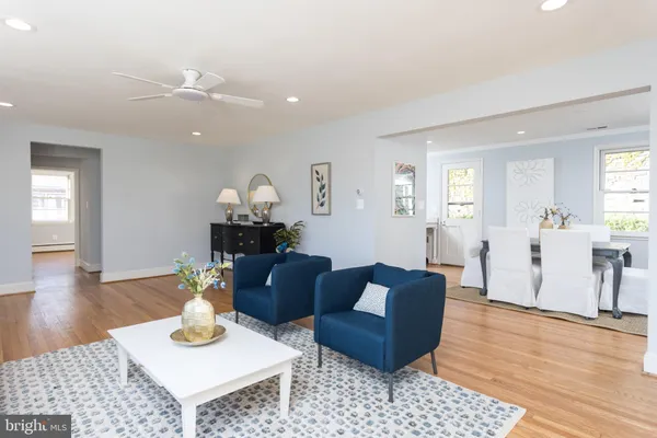 a living room with furniture a large window and wooden floor