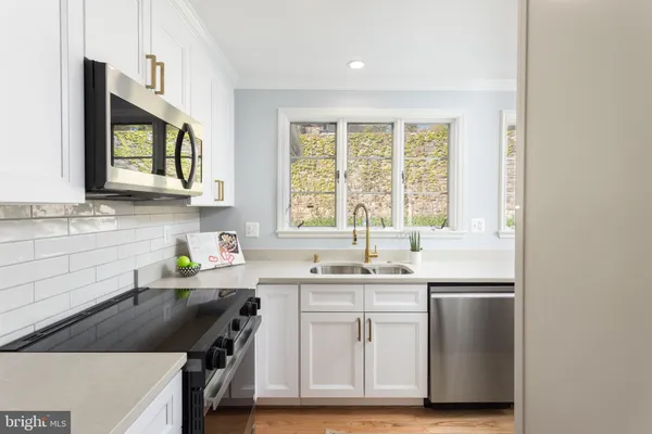 a kitchen with a stove a sink a microwave a dining table and chairs