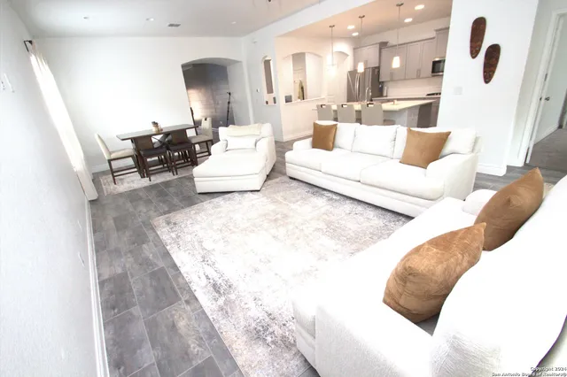 a living room with furniture and a wooden floor