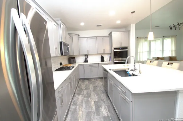 a kitchen with white cabinets and stainless steel appliances